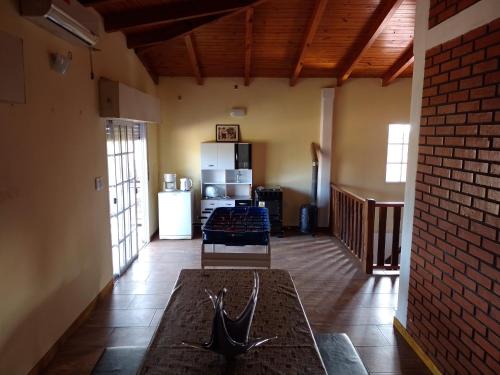 a living room with a table and a kitchen with a refrigerator at Hospedaje Los Laureles in Wanda