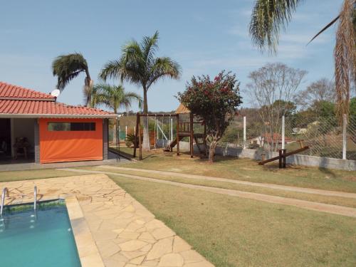 uma casa com piscina e palmeiras em Chácara Recanto da Paz em Pinhalzinho