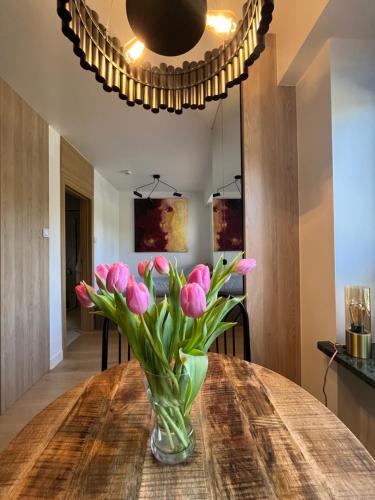 a vase of pink tulips sitting on a table at Gold Pearl Zegrze in Serock