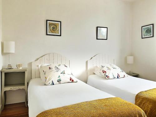 2 camas en una habitación con paredes blancas en Gîte ti Goudoul bébés enfants friendly en Moëlan-sur-Mer
