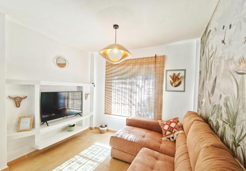 a living room with a couch and a television at Casa Bakara Zahara beach in Zahara de los Atunes