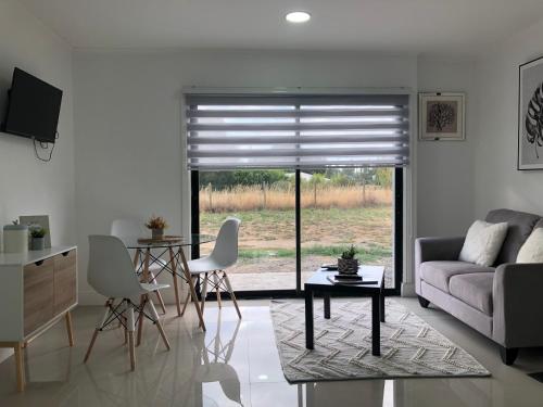 sala de estar con sofá y mesa en Departamento Los Canelos, a metros de Avenida Las Industrias, incluye aire acondicionado, en Los Ángeles