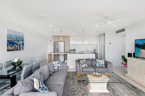 a living room with two couches and a kitchen at Modern Contemporary Southport Apartment in Gold Coast