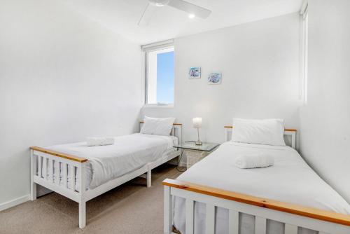 2 camas en una habitación con ventana en Modern Contemporary Southport Apartment en Gold Coast