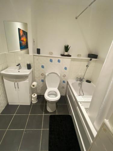 a bathroom with a toilet and a tub and a sink at Modern 2-Bed Apartment in Glasgow SECC/HYDRO in Glasgow