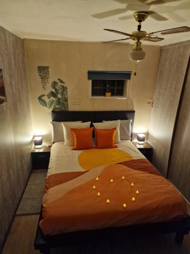 1 dormitorio con 1 cama grande con almohadas de color naranja en mignon, en Soumagne