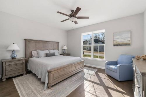 1 dormitorio con 1 cama y 1 silla azul en Beautiful Home with Lake and Marina Access, Firepit, Golf Cart Included, en Estill Springs