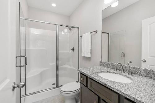 a bathroom with a shower and a toilet and a sink at Beautiful Home with Lake and Marina Access, Firepit, Golf Cart Included in Estill Springs