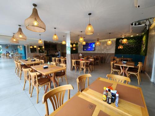 a restaurant with wooden tables and chairs and lights at Apart Hotel Alecrim Praia de Camboinhas com Marina pe na areia in Niterói