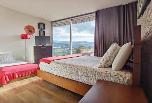 a bedroom with two beds and a large window at Quinta de Padreiro in Arcos de Valdevez