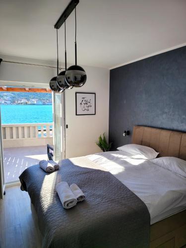 1 dormitorio con 1 cama grande y toallas. en Kupinica Apartment, en Vinišće