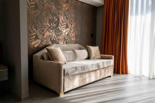 a couch sitting in a room with a wall at Divina Charme in Mascalucia
