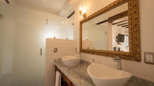 a bathroom with two sinks and a mirror at Villa Toscana ValQuirico Lofts & Suites Hotel Boutique in Santeagueda