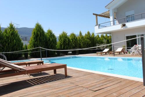 a villa with a swimming pool and a house at Alkistis Hotel in Diakopto