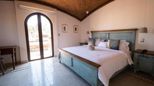 a bedroom with a large bed and a large window at Villa Toscana ValQuirico Lofts & Suites Hotel Boutique in Santeagueda