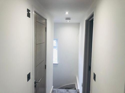 a hallway with a mirror and a door to a bathroom at Diamond accommodation in London