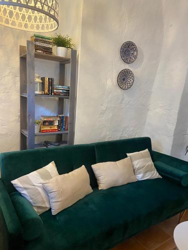 a green couch with pillows in a living room at Acogedora Casa Rural en Olvera La Morada in Olvera