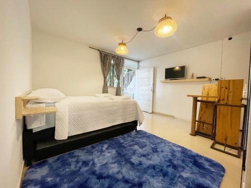 1 dormitorio con cama y alfombra azul en Selvática Alojamiento Eco en Medellín