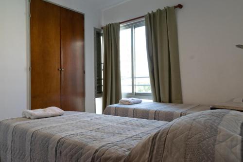 pokój hotelowy z 2 łóżkami i oknem w obiekcie Cómodo y Agradable Departamento Céntrico w mieście Rosario