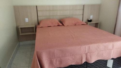 a bedroom with a pink bed with two pink pillows at CALDAS NOVAS - GO - Apartamento Parque das Aguas Quentes bloco 1 - em frente Clube Privê in Caldas Novas