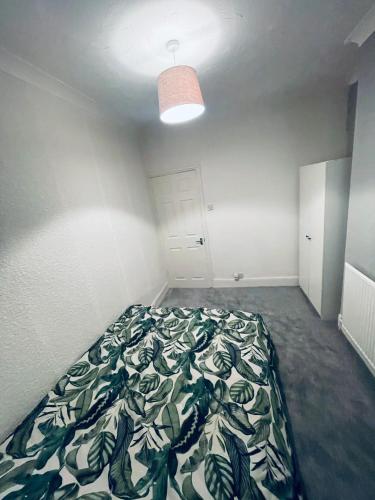 - une chambre dotée d'un lit avec une couverture verte et blanche dans l'établissement Shou’s guest house, à Newport