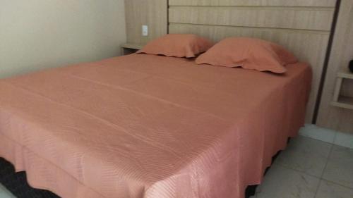 a pink bed with two pillows on top of it at CALDAS NOVAS - GO - Apartamento Parque das Aguas Quentes bloco 1 - em frente Clube Privê in Caldas Novas
