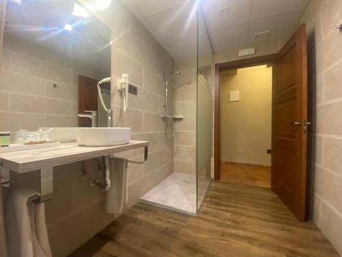 La salle de bains est pourvue d'un lavabo, d'une douche et d'un miroir. dans l'établissement Hotel Rural El Lagar de Nemesio, à Perales de Tajuña