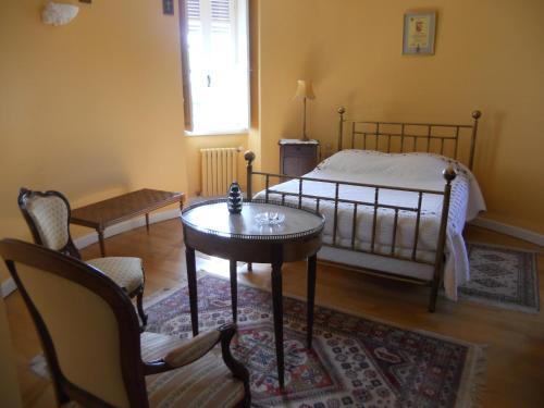 a bedroom with a bed and a table and chairs at Château de la Moissetie in Aurillac