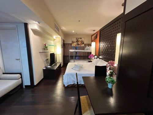 Habitación de hotel con cama y sofá en SunwayLagoonFamilySuite-4-7pax-Netflix-Balcony-Super Fast Internet, en Kampong Penaga