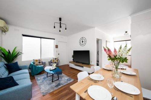 a living room with a blue couch and a table at Sun and Sand Albert Park in Melbourne