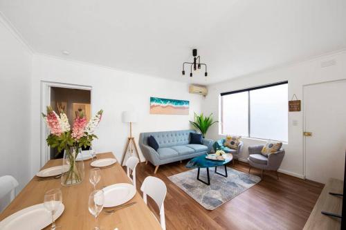 a living room with a blue couch and a table at Sun and Sand Albert Park in Melbourne