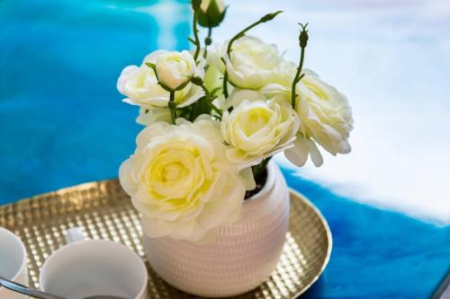 a vase filled with white roses sitting on a table at Sun and Sand Albert Park in Melbourne
