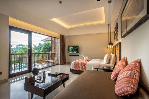 a hotel room with two beds and a balcony at Sanctoo Suites & Villas in Gianyar