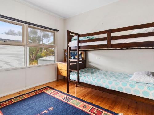 sypialnia z 2 łóżkami piętrowymi i niebieskim dywanem w obiekcie 4 Wilto Street w mieście Normanville