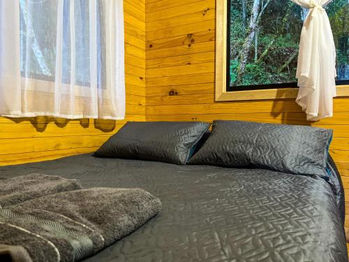 a bed in a room with a window at Vital Ecohotel Cabañas in Guarne