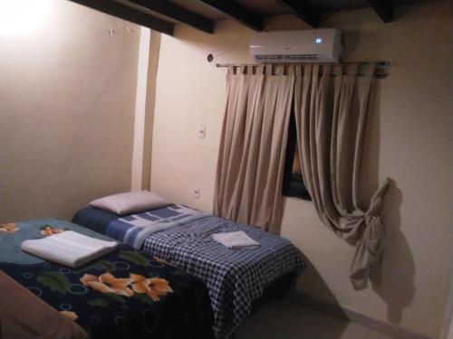 2 camas individuales en una habitación con cortina en Pocha Roga, en Asunción