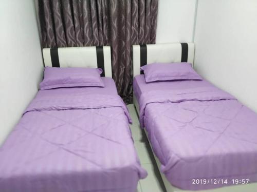 - 2 lits dans une chambre avec des draps violets dans l'établissement Lavender home, à Nilai