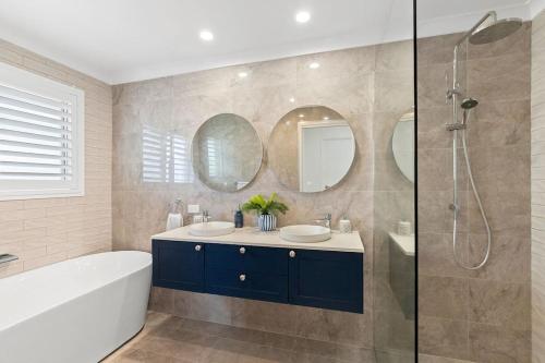 a bathroom with two sinks and a tub and a shower at Mooloolaba Oasis 4bd Home, Pool in Mooloolaba