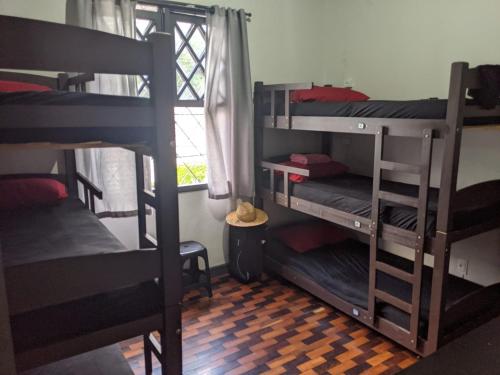 a room with three bunk beds and a window at Youkoso Hostel in Florianópolis