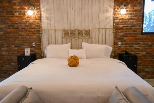 a large white bed with a brown bow on it at Villa Toscana ValQuirico Lofts & Suites Hotel Boutique in Santeagueda
