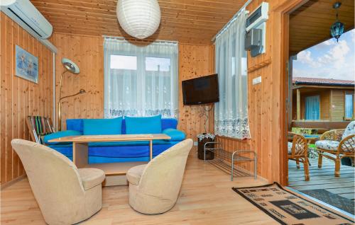 salon z niebieską kanapą, stołem i krzesłami w obiekcie 2 Bedroom Amazing Home In Wicie w Wiciu