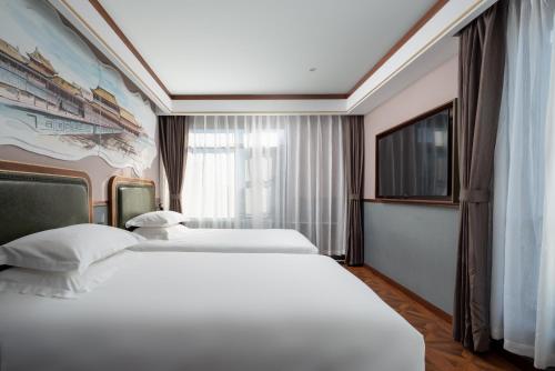 a hotel room with two beds and a tv at Nostalgia S Hotel Beijing Financial Street 时光漫步S酒店 北京西单金融街店 Free fresh ground coffee,Free laundry service in Beijing