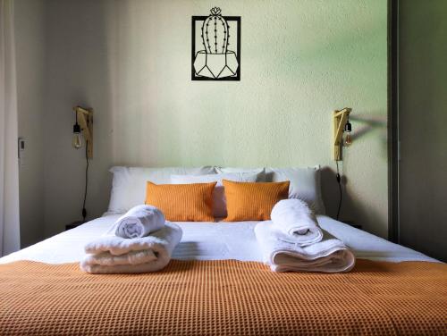 a bed with two towels on top of it at Entre Uvas y Siestas - Casa Álamos in Chacras de Coria