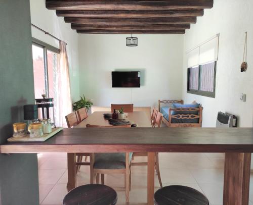 comedor y sala de estar con mesa y sillas en Entre Uvas y Siestas - Casa Álamos en Chacras de Coria