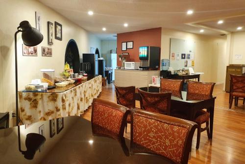 a living room with a table and chairs and a kitchen at Cloud 9 Inn in Whitecourt