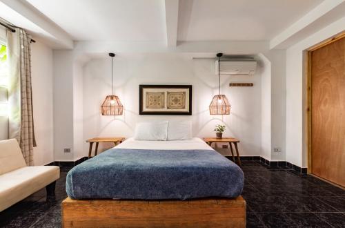 1 dormitorio con 1 cama, 2 mesas y 2 lámparas en Cinco Hotel B&B, en San Salvador