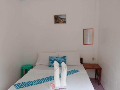 a bedroom with a bed with white shoes on it at Bucana beachfront guesthouse in El Nido