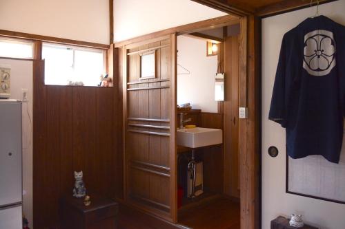a small bathroom with a sink and a mirror at ZOKUIJINKAN GUESTHOUSe 続異人館 in Arita