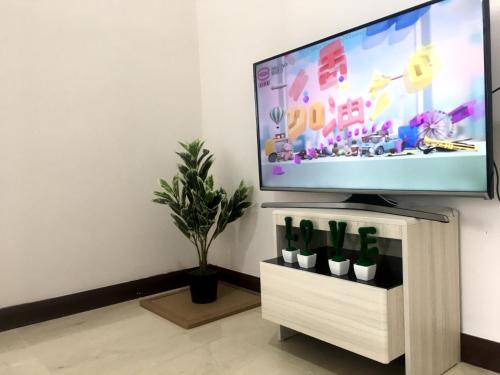 Elle comprend une télévision à écran plat installée au-dessus d'une table de télévision. dans l'établissement Studio Unit with Seaview & Wifi, à Malacca