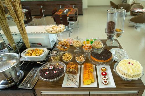 ポルト・ヴェーリョにあるGolden Plaza Hotelの様々な種類のデザートを用意しています。